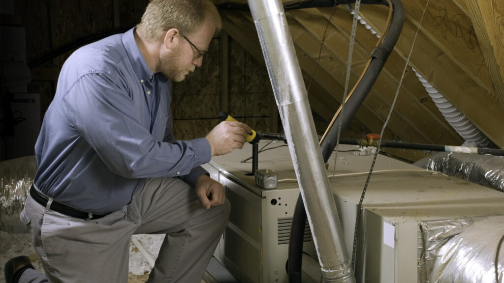 An HVAC technician doing a furnace tune-up