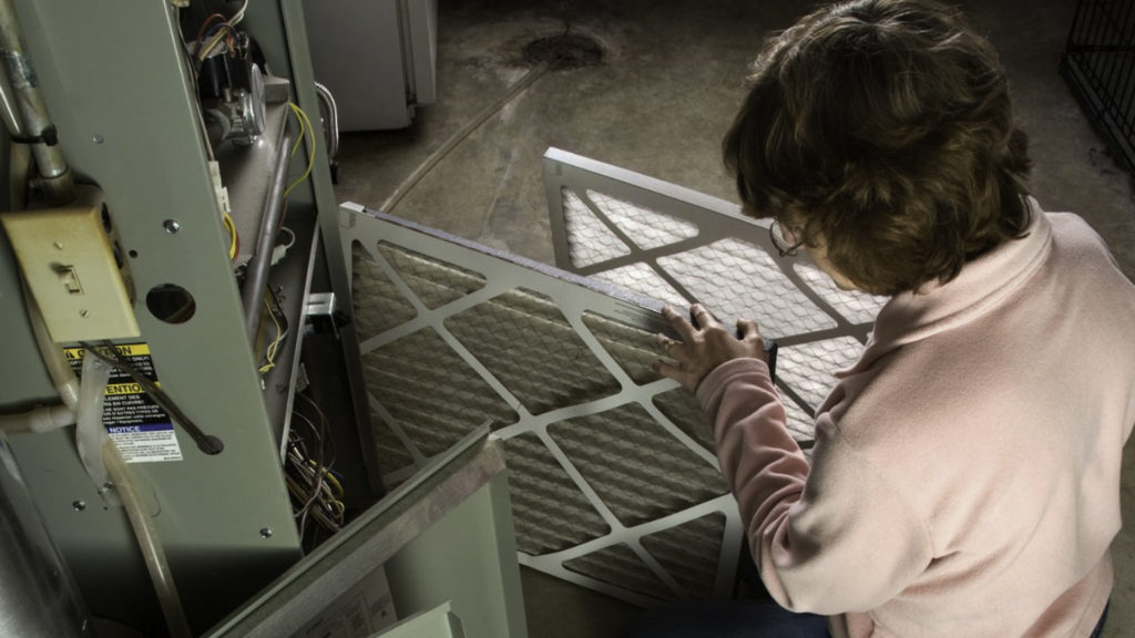 woman changing and hvac filter