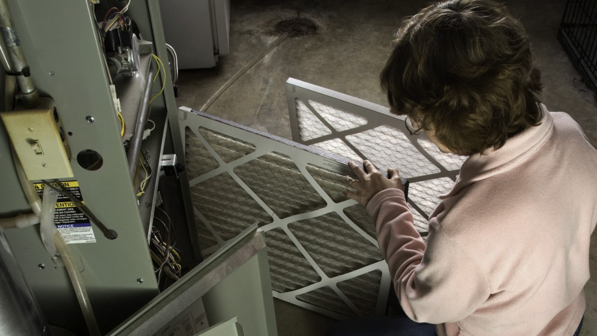 woman changing a hvac filter. Part of a furnace tune-up